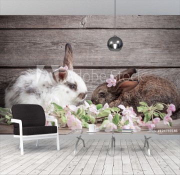 Bild på Two  rabbits with flowers on wooden  background